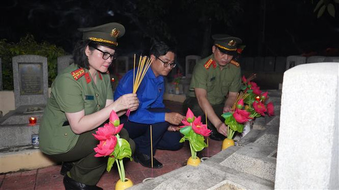 Thắp hương tri ân các anh hùng liệt sỹ tại nghĩa trang liệt sỹ Đồi 82 Tân Biên. (Ảnh: Thanh Tân/TTXVN) Tuổi trẻ cả nước thắp nến tri ân các anh hùng, liệt sỹ ảnh 5