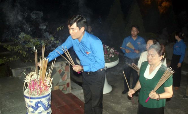 Anh Lê Văn Châu, Bí thư tỉnh đoàn Thanh Hóa và các người dân thắp hương tưởng nhớ các anh hùng liệt sỹ. (Ảnh: Nguyễn Nam/TTXVN) Tuổi trẻ cả nước thắp nến tri ân các anh hùng, liệt sỹ ảnh 3