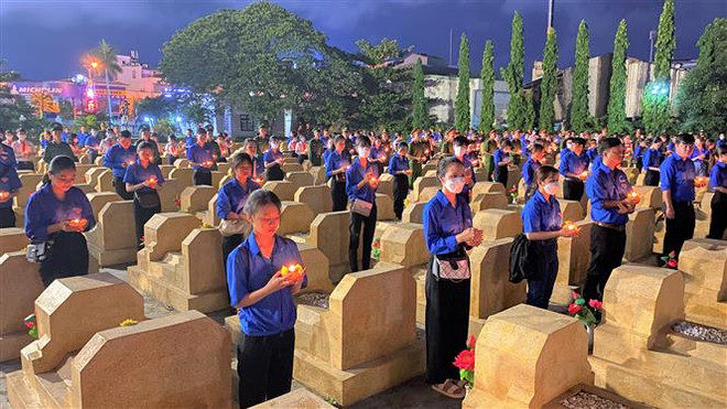 Đoàn viên thanh niên thắp nén tri ân tại các phần mộ liệt sỹ thuộc nghĩa trang liệt sỹ thành phố Quy Nhơn. (Ảnh: Tường Quân/TTXVN) Tuổi trẻ cả nước thắp nến tri ân các anh hùng, liệt sỹ ảnh 4