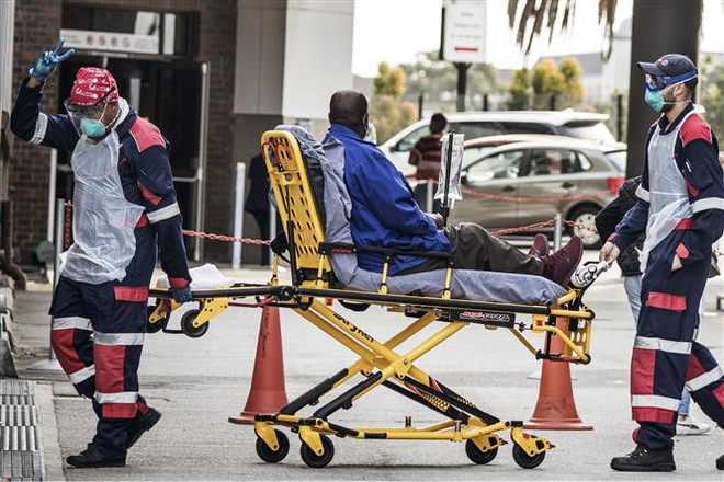 Nhân viên y tế chuyển bệnh nhân mắc COVID-19 vào một bệnh viện ở Port Elizabeth, Nam Phi. (Ảnh: AFP/TTXVN) Giải bài toán thiếu hụt vaccine phòng COVID-19 cho châu Phi ảnh 3