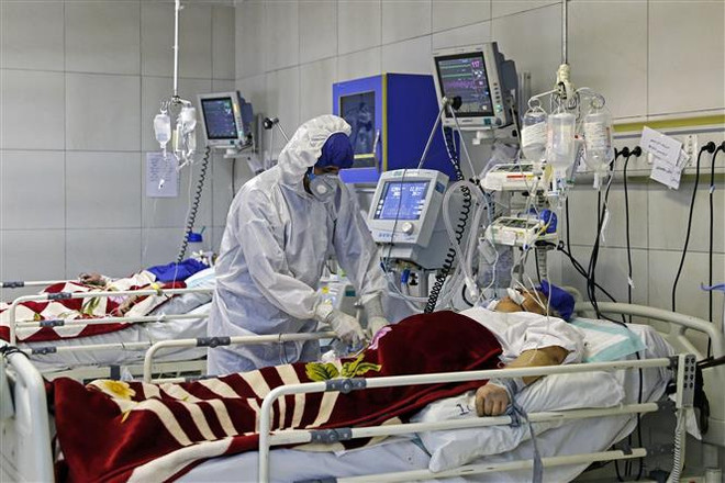 Nhân viên y tế điều trị cho bệnh nhân COVID-19 tại bệnh viện ở Tehran, Iran. (Ảnh: AFP/TTXVN) Iran có số ca tử vong do COVID-19 trong ngày cao nhất hai tháng qua ảnh 1