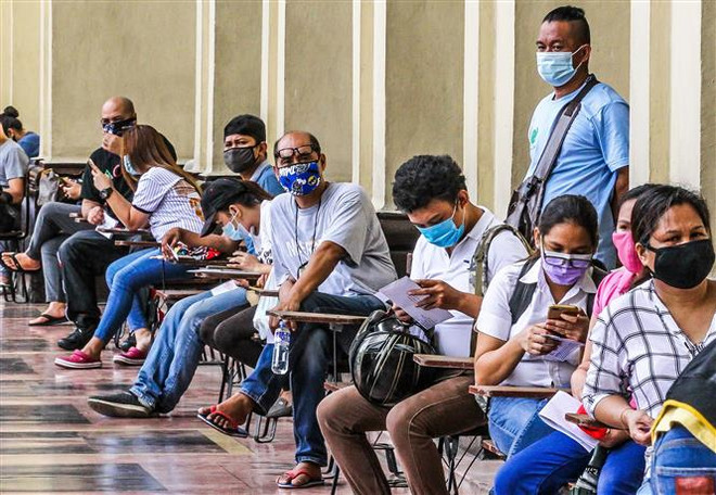 Người dân đeo khẩu trang phòng lây nhiễm COVID-19 khi xếp hàng bên ngoài bưu điện ở Manila, Philippines. (Ảnh: THX/TTXVN) Philippines và Indonesia ghi nhận hàng nghìn ca mắc COVID-19 mới ảnh 1