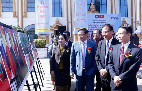 Ông Nguyễn Đức Lợi, Ủy viên Trung ương Đảng, Tổng Giám đốc Thông tấn xã Việt Nam Nguyễn Đức Lợi (phải) cùng các quan khách đang đi thăm quan Triển lãm ảnh. (Ảnh: Phạm Kiên/Vietnam+) TTXVN và KPL trưng bày ảnh tư liệu quý về mối quan hệ Việt Nam-Lào ảnh 1