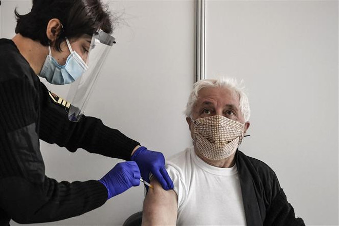 Nhân viên y tế tiêm vaccine ngừa COVID-19 của Moderna cho người dân tại Athens, Hy Lạp. (Ảnh: AFP/TTXVN) Châu Âu phê duyệt sử dụng vaccine của Pfizer/BioNTech cho trẻ em ảnh 2