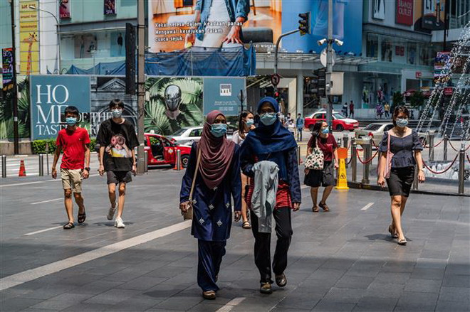 Người dân đeo khẩu trang phòng lây nhiễm COVID-19 tại Kuala Lumpur, Malaysia. (Ảnh: AFP/TTXVN) Malaysia ghi nhận số ca mắc mới cao nhất từ khi dịch bùng phát ảnh 1