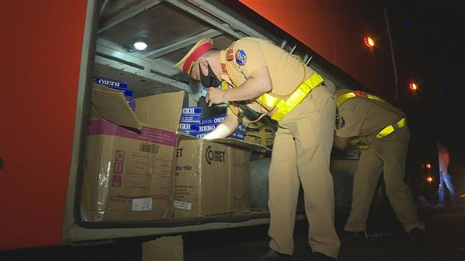 Lực lượng công an kiểm tra số thuốc lá lậu trên xe. (Ảnh: TTXVN phát) Đắk Lắk phát hiện xe khách giường nằm vận chuyển thuốc lá lậu ảnh 1