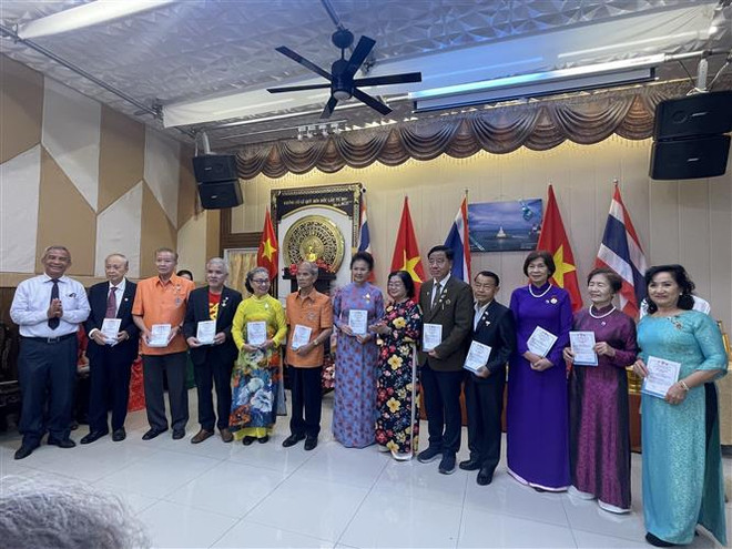 Nguyên Phó Chủ tịch nước Trương Mỹ Hoa trao chứng nhận hội viên Câu lạc bộ “Vì Hoàng Sa-Trường Sa thân yêu” cho các kiều bào tại Udon Thani. (Ảnh TTXVN phát) Kiều bào Việt Nam tại Thái Lan hướng về biển đảo quê hương ảnh 1