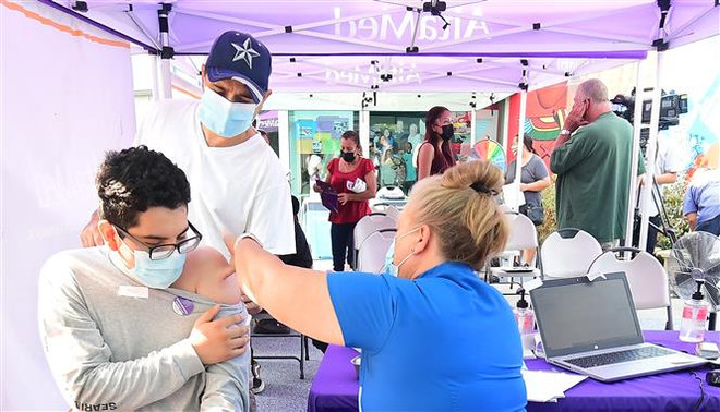 Nhân viên y tế tiêm vaccine ngừa COVID-19 cho người dân tại Los Angeles, California, Mỹ. (Ảnh: AFP/TTXVN) FDA Mỹ đánh giá dữ liệu liên quan liều tăng cường vaccine COVID ảnh 1