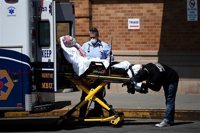 Nhân viên y tế chuyển bệnh nhân COVID-19 tới trung tâm y tế Maimonides ở New York, Mỹ. (Ảnh: AFP/TTXVN) Thế giới có gần 40 triệu ca nhiễm COVID-19, hơn 1,1 triệu ca tử vong ảnh 1