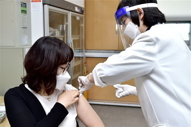 Một nhân viên y tế được tiêm vắcxin ngừa COVID-19. (Ảnh: Yonhap/TTXVN) COVID-19: "Hộ chiếu vắcxin" đang gây chia rẽ cộng đồng quốc tế ảnh 1