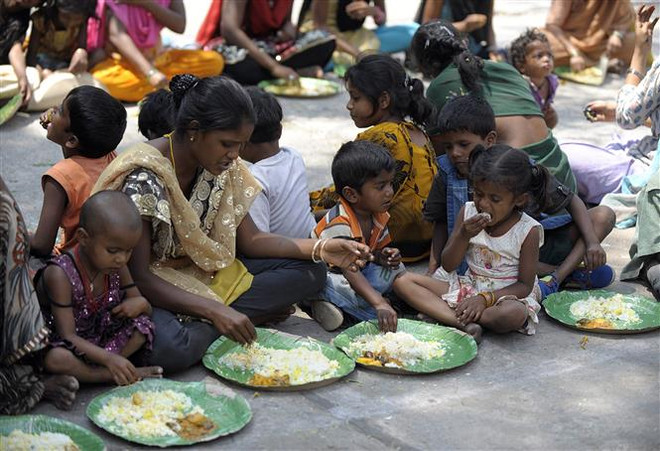 Người vô gia cư nhận thức ăn từ một chương trình cứu trợ dành cho người nghèo ở Hyderabad, Ấn Độ nắm 2019. (Ảnh: AFP/TTXVN) LHQ: Tình trạng mất an ninh lương thực gia tăng từ trước dịch COVID-19 ảnh 1