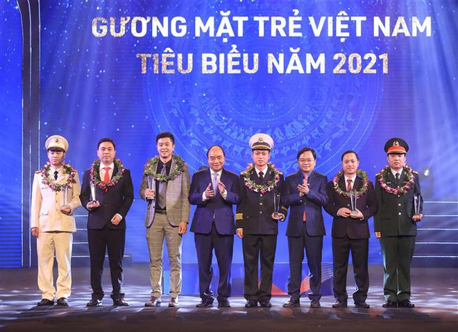 Chủ tịch nước Nguyễn Xuân Phúc và Bí thư thứ nhất TƯ Đoàn Nguyễn Anh Tuấn trao biểu trưng tuyên dương các Gương mặt trẻ Việt Nam tiêu biểu năm 2021. (Ảnh: Thống Nhất/TTXVN) Vinh danh các tài năng trẻ xuất sắc trong xây dựng và bảo vệ Tổ quốc ảnh 1