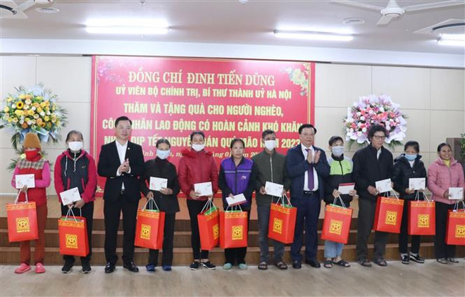 Ủy viên Bộ Chính trị, Bí thư Thành ủy Đinh Tiến Dũng trao quà tặng các hộ nghèo, hộ có hoàn cảnh khó khăn trên địa bàn tỉnh Ninh Bình. (Ảnh: Đức Phương/TTXVN) Ủy viên Bộ Chính trị Đinh Tiến Dũng thăm, tặng quà Tết tại Ninh Bình ảnh 2