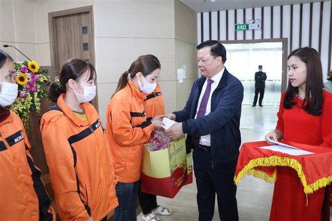 Ủy viên Bộ Chính trị, Bí thư Thành ủy Hà Nội Đinh Tiến Dũng trao quà tặng các công nhân trên địa bàn tỉnh Ninh Bình. (Ảnh: Đức Phương/TTXVN) Ủy viên Bộ Chính trị Đinh Tiến Dũng thăm, tặng quà Tết tại Ninh Bình ảnh 1