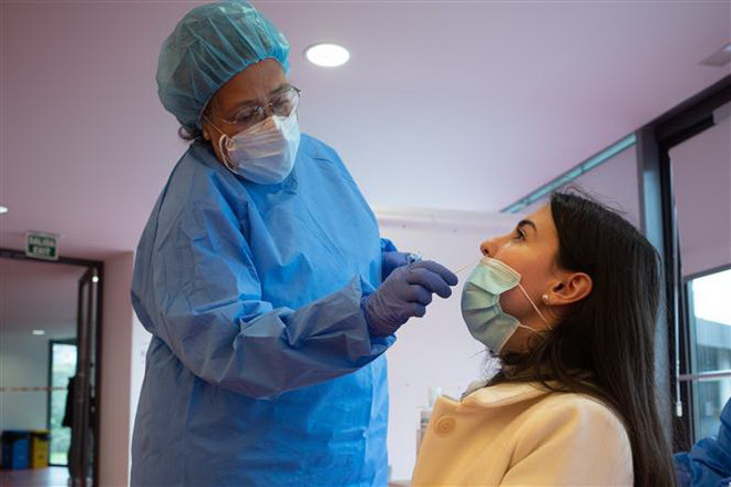 Nhân viên y tế lấy mẫu xét nghiệm COVID-19 tại Madrid, Tây Ban Nha. (Ảnh: THX/TTXVN) Châu Âu tìm lối vượt qua làn sóng dịch bệnh COVID-19 thứ ba ảnh 3