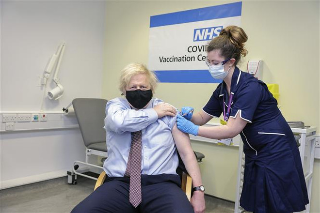 Nhân viên y tế tiêm vaccine ngừa COVID-19 cho Thủ tướng Anh Boris Johnson tại bệnh viện ở London. (Ảnh: THX/TTXVN) Anh kêu gọi G7 đạt đồng thuận về hộ chiếu vaccine ngừa COVID-19 ảnh 1