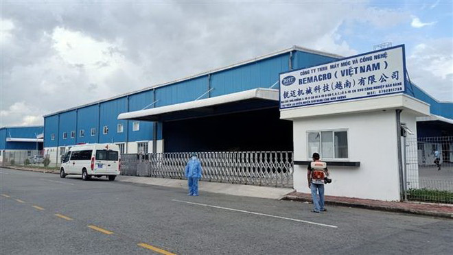 Lực lượng chức năng phong tỏa, khử khuẩn Công ty Remacro. (Ảnh: TTXVN phát) Bình Dương nâng cao ý thức trách nhiệm phòng dịch tại doanh nghiệp ảnh 1