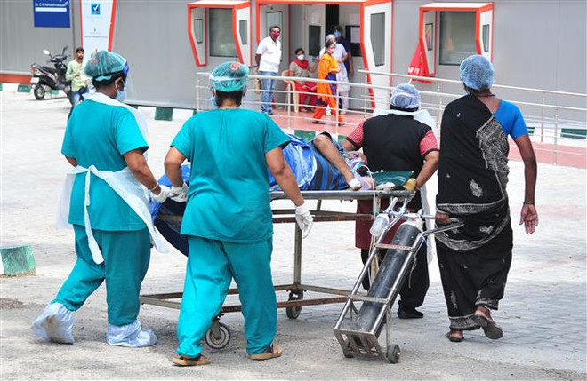 Nhân viên y tế chuyển bệnh nhân nhiễm COVID-19 tới bệnh viện ở Bangalore, Ấn Độ. (Ảnh: THX/TTXVN) Số ca mắc mới tại Ấn Độ dưới ngưỡng 100.000 ngày thứ 8 liên tiếp ảnh 1