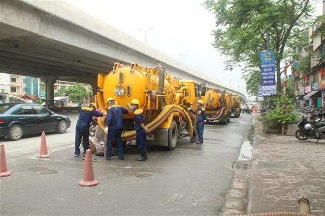 Công nhân Công ty TNHH MTV Thoát nước Hà Nội thi công nạo vét bùn cống ngang bằng thiết bị cơ giới. (Ảnh: Mạnh Khánh/TTXVN) Hà Nội: Nhiều biện pháp giúp công nhân chống chọi với nắng nóng ảnh 2