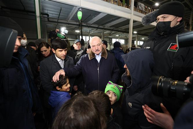 Tổng thống Belarus Alexander Lukashenko (giữa) thăm hỏi những người di cư gần chốt kiểm soát Bruzgi ở khu vực biên giới với Ba Lan. (Ảnh: THX/TTXVN) Belarus phản đối các biện pháp trừng phạt mới của phương Tây ảnh 1