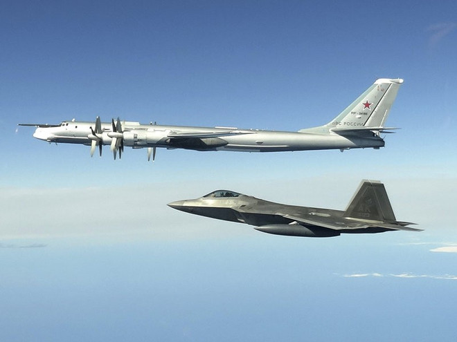Máy bay ném bom Tu-95 của Nga (trên) và tiêm kích F-22 Raptor của Mỹ. (Ảnh: North American Aerospace Defense Command/AP) Nga xúc tiến các thủ tục rút khỏi Hiệp ước Bầu trời mở ảnh 1