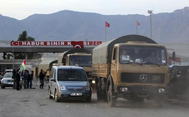 Một đoàn xe của chiến binh peshmerga (phải) đến cửa khẩu Habur ngày 29/10. (Nguồn: Reuters) Người Kurd ở Iraq đưa vũ khí chủ lực tới Syria hỗ trợ chống IS ảnh 1