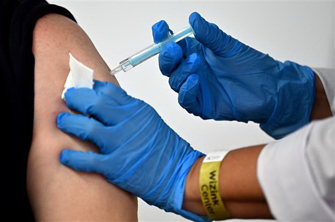 Nhân viên y tế tiêm vaccine AstraZeneca ngừa COVID-19 cho người dân. (Ảnh: AFP/TTXVN) Hướng dẫn tiêm AstraZeneca cho người có tiền sử chảy máu hiếm gặp ảnh 1