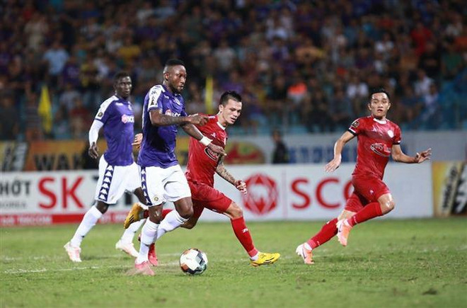 Hà Nội FC (áo tím) gặp đội Hồ Chí Minh FC (áo đỏ). (Ảnh: Trọng Đạt/TTXVN) V-League 2019: Điểm tên đội bóng vô địch lượt đi sau vòng đấu 12 ảnh 1