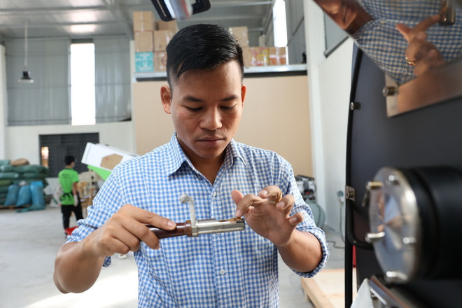 Anh Y Pôt Niê kiểm tra chất lượng hạt cà phê rang xay. (Ảnh: Tuấn Anh/TTXVN) ttxvn-chang_trai_e_de2.jpg