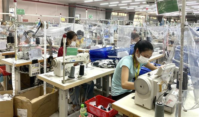 Để đảm bảo an toàn cho các công nhân, một công ty triển khai dựng tấm chắn trong phân xưởng sản xuất. (Ảnh: Mai Trang/TTXVN) Doanh nghiệp hiến kế xử lý các vấn đề sau kiểm soát dịch COVID-19 ảnh 2