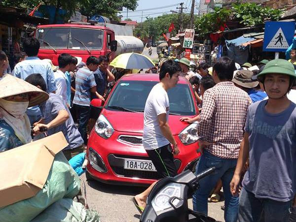 Hàng chục người vây kín chiếc xe (Ảnh: PV/Vietnam+) Hà Nội: Hàng chục người vây bắt nhóm trộm thẻ điện thoại ảnh 1