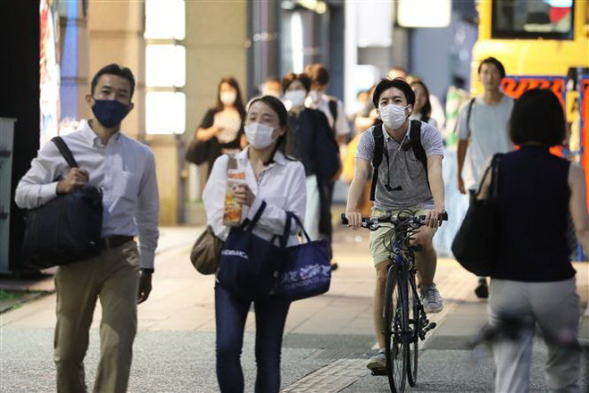 Người dân đeo khẩu trang phòng lây nhiễm COVID-19 tại Tokyo, Nhật Bản. (Ảnh: THX/TTXVN) Virus SARS-CoV-2 có khả năng tấn công não bộ của bệnh nhân ảnh 2