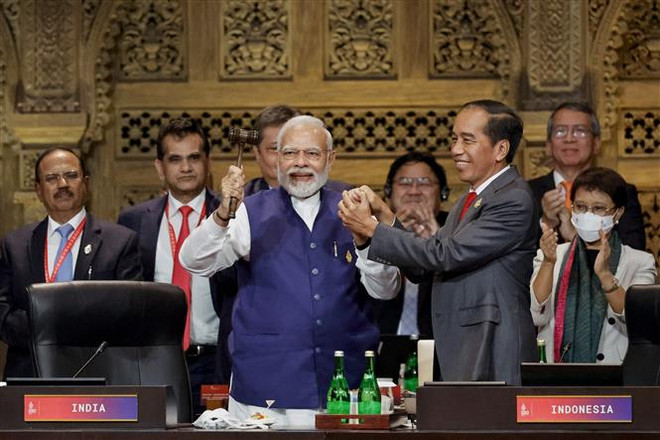 Tổng thống Indonesia Joko Widodo (phải, hàng trước) trao búa chuyển giao cương vị Chủ tịch G20 cho Thủ tướng Ấn Độ Narendra Modi (trái, hàng trước) tại lễ bế mạc Hội nghị thượng đỉnh G20 ở Bali (Indonesia), ngày 16/11. (Ảnh: AFP/TTXVN) Ấn Độ nhấn mạnh ưu tiên trong nhiệm kỳ Chủ tịch luân phiên G20 ảnh 1