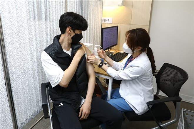 Nhân viên y tế tiêm vaccine ngừa COVID-19 cho người dân tại Seoul, Hàn Quốc. (Ảnh: AFP/TTXVN) IMF đề xuất kế hoạch chấm dứt đại dịch trị giá 50 tỷ USD ảnh 1