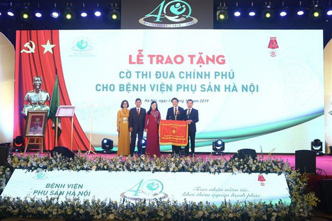 Bộ trưởng Bộ Y tế Nguyễn Thị Kim Tiến tặng Cờ thi đua của Chính phủ cho Bệnh viện Phụ sản Hà Nội. (Ảnh: Minh Quyết/TTXVN) Bệnh viện Phụ sản Hà Nội đón nhận huân chương lao động hạng nhất lần 2 ảnh 1