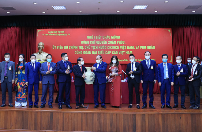 Chủ tịch nước Nguyễn Xuân Phúc tặng quà cho Hội doanh nghiệp Việt Nam hợp tác đầu tư tại Lào. (Ảnh: Thống Nhất/TTXVN) Chủ tịch nước gặp đại diện cộng đồng và doanh nghiệp Việt Nam tại Lào ảnh 2