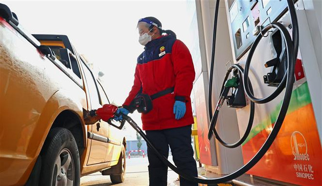 Bơm xăng cho các phương tiện tại một cây xăng ở tỉnh Giang Tô, Trung Quốc. (Ảnh: AFP/TTXVN) Giá vàng đảo chiều tăng trong khi giá dầu gần như đứng yên ảnh 2