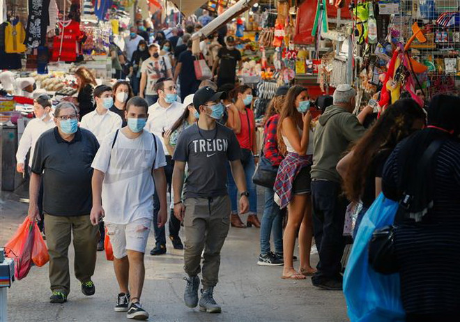 Người dân đeo khẩu trang phòng lây nhiễm COVID-19 tại một khu chợ ở Tel Aviv, Israel. (Ảnh: AFP/TTXVN) Số ca nhiễm COVID-19 mới tại Trung Đông vẫn gia tăng mạnh ảnh 1
