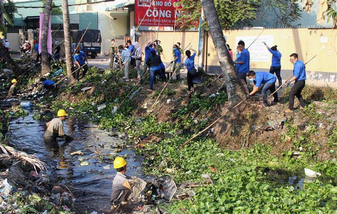 Các lực lượng dọn dẹp vệ sinh môi trường trên rạch Đất Sét, Thành phố Hồ Chí Minh. (Ảnh: Xuân Dự/TTXVN) Chiến dịch thanh niên tình nguyện Hè được triển khai đến tháng 8 ảnh 2