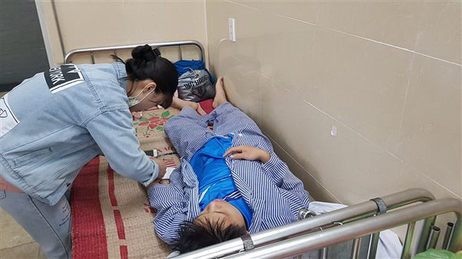 Người nhà chăm sóc cho cháu Phạm Công Khanh, người bị giáo viên dạy võ đánh vỡ xương hàm. (Ảnh: Minh Thu/TTXVN) Đình chỉ giáo viên karate liên quan vụ đánh vỡ xương hàm học sinh ảnh 1
