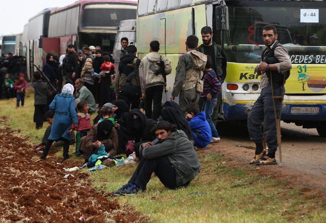 Xe buýt chở các tay súng nhóm Jaish al-Islam và gia đình rời rời khỏi Đông Ghouta đến miền Bắc Syria. (Nguồn: AFP/TTXVN) Syria: Phiến quân Jaish al-Islam đạt thỏa thuận rời thị trấn Dumayr ảnh 1