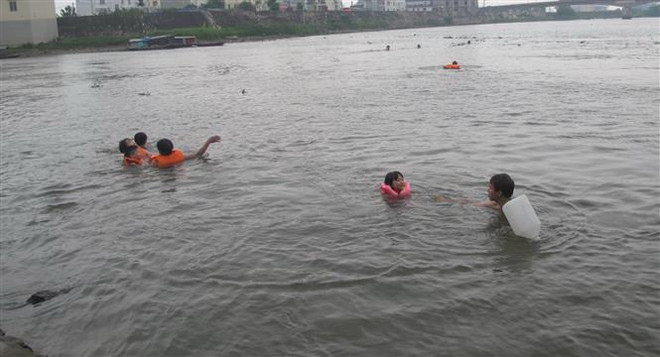 Trẻ em bơi tại khu vực Núi Thúy, thành phố Ninh Bình bất chấp nguy hiểm. (Ảnh: Hải Yến/TTXVN) Cảnh báo tình trạng đuối nước ở trẻ em nông thôn vào mùa Hè ảnh 1