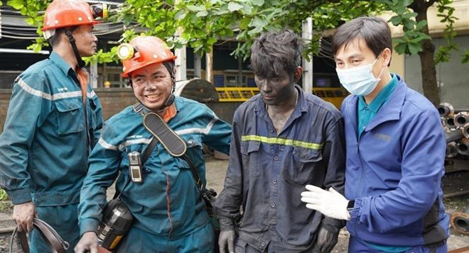 Lực lượng cứu hộ đưa công nhân Phạm Công Nhiên bị mắc kẹt ra khỏi vị trí an toàn. (Ảnh: TTXVN phát) Cứu hộ thành công hai công nhân bị kẹt trong sự cố ở Than Vàng Danh ảnh 1
