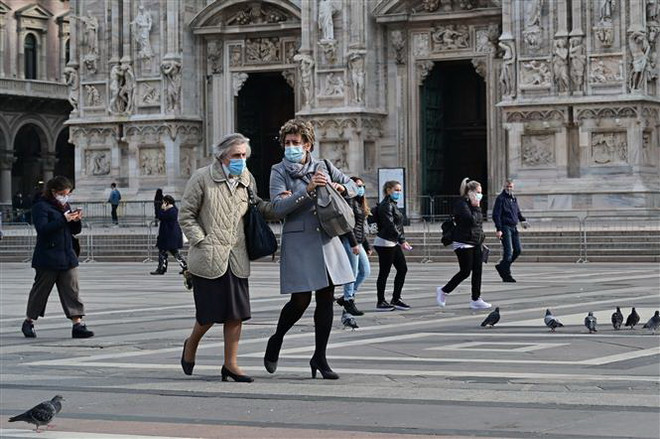 Người dân đeo khẩu trang phòng lây nhiễm COVID-19 tại Milan, Italy. (Ảnh: AFP/TTXVN) Italy thông qua gói kích thích kinh tế thứ tư trị giá 8 tỷ euro ảnh 1