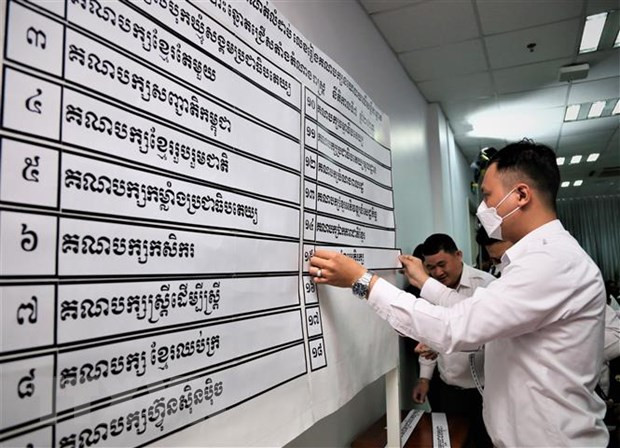 Nhân viên NEC niêm yết kết quả xếp thứ tự 18 chính đảng tham gia tổng tuyển cử năm 2023. (Ảnh: Huỳnh Thảo/TTXVN) Thượng viện Campuchia thông qua toàn văn dự thảo Luật Bầu cử sửa đổi ảnh 1
