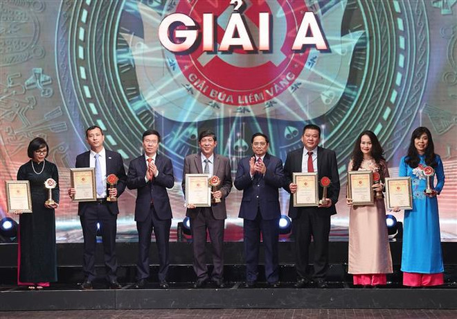 Thủ tướng Phạm Minh Chính và Thường trực Ban Bí thư Võ Văn Thưởng trao giải A cho các tác giả, nhóm tác giả. (Ảnh: Dương Giang/TTXVN) Lễ trao Giải báo chí toàn quốc về xây dựng Đảng mang tên Búa liềm vàng ảnh 4