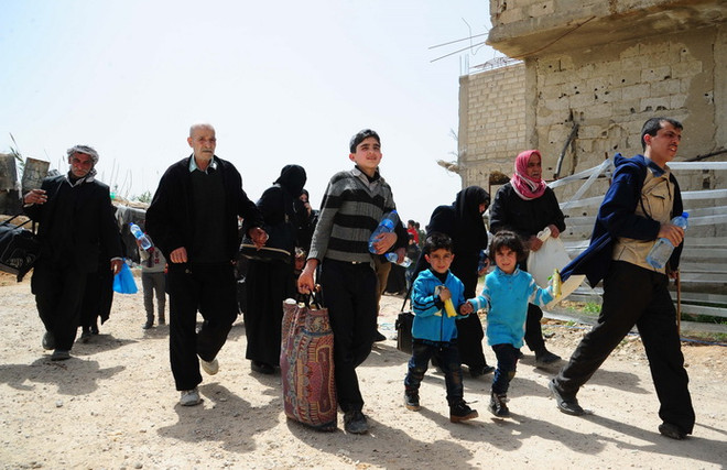 Thường dân Syria rời khỏi Douma tới khu vực do Chính phủ kiểm soát ở Wafidin, phía bắc Damascus ngày 27/3. (Nguồn: THX/TTXVN) Syria: Tổ chức Trăng lưỡi liềm Đỏ không tìm thấy chất độc ở Douma ảnh 1