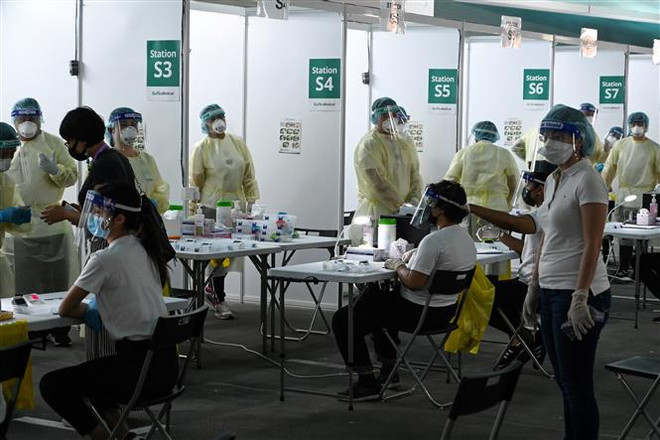 Một điểm xét nghiệm COVID-19 tại Singapore. (Ảnh: AFP/TTXVN) Singapore thắt chặt trở lại các biện pháp giãn cách xã hội ảnh 1
