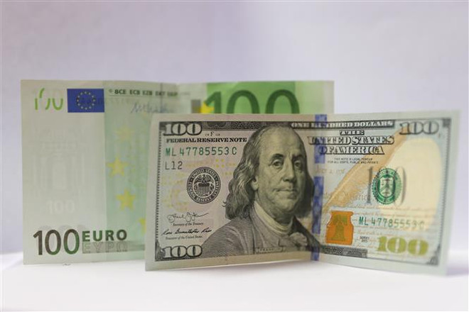 Đồng euro (phía sau) và đồng USD tại Brussels, Bỉ. (Ảnh: THX/TTXVN) Đồng euro của châu Âu sẽ mất giá đến mức nào? ảnh 1