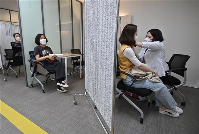 Nhân viên y tế tiêm vaccine phòng COVID-19 cho người dân tại Seoul, Hàn Quốc. (Ảnh: AFP/ TTXVN) Hàn Quốc triển khai biện pháp mới phòng dịch COVID-19 ảnh 1